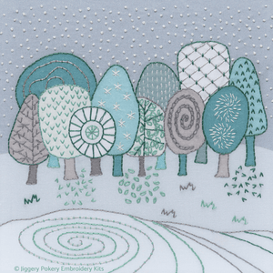 Winter landscape embroidery kit showing a group of Scandi style trees against a grey background