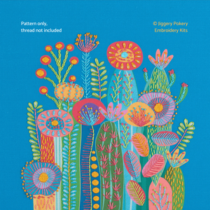 Cactus embroidery pattern on bright blue fabric creating a display of cactus flowers which burst with colour