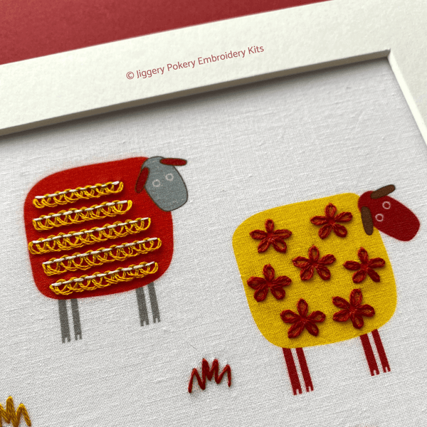 Sheep embroidery design close up of red and yellow sheep