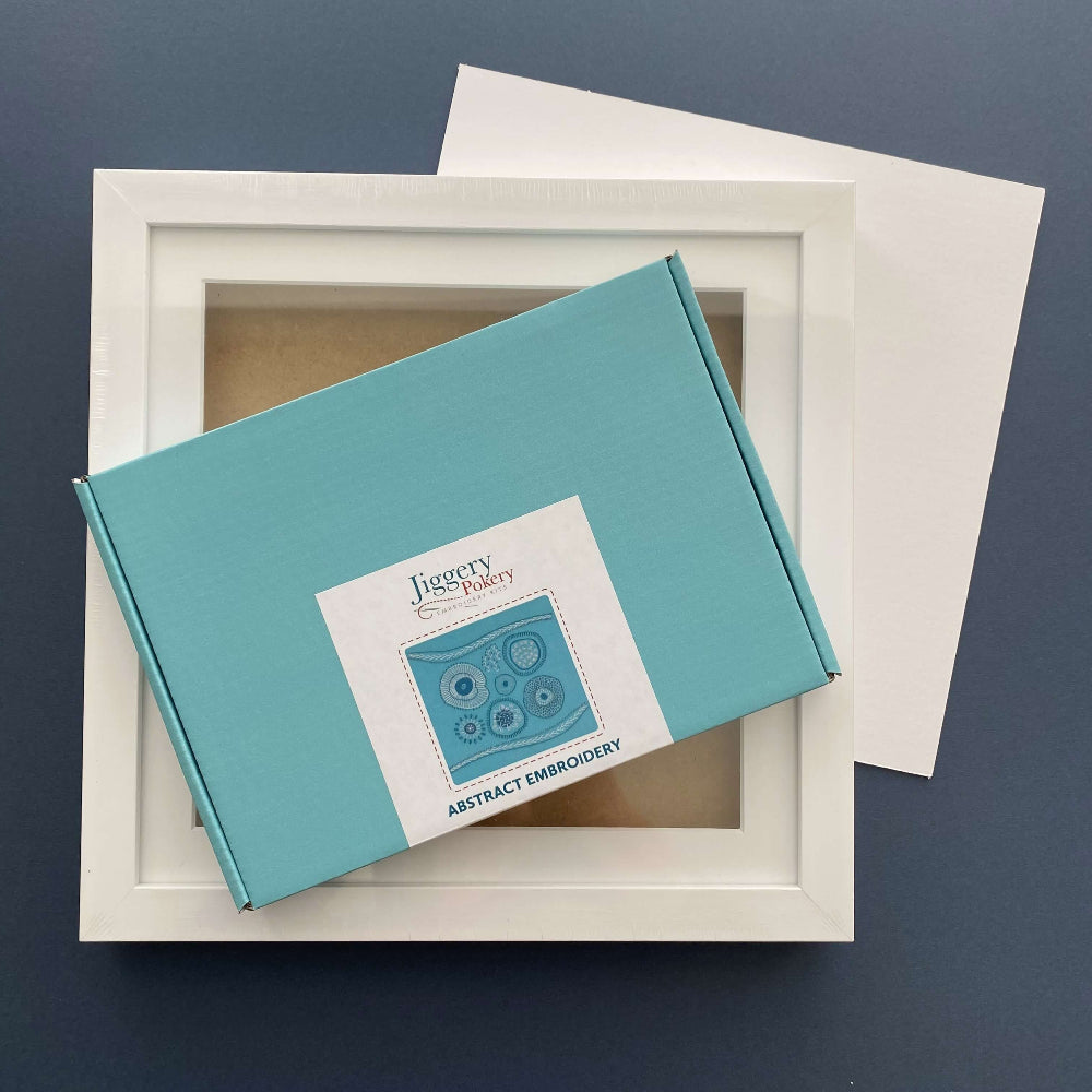 Abstract embroidery kit and square white frame with a piece of mountboard cut to size