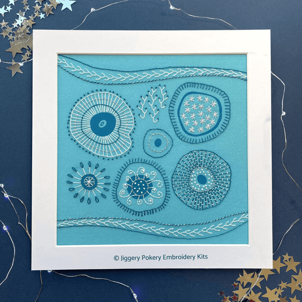 Abstract embroidery kit shown in white mount on a navy blue background with lights and starsblue 