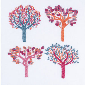 Autumn embroidery showing four trees using non-traditional DMC thread colours of salmon pink, air force blue, crimson, flame and pink.
