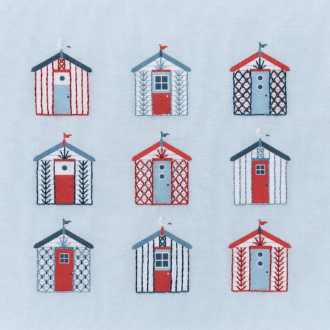 Beach embroidery kit showing 9 beach huts using simple embroidery stitches. The DMC thread colours are red, dark blue and blue on a printed pale blue-grey background