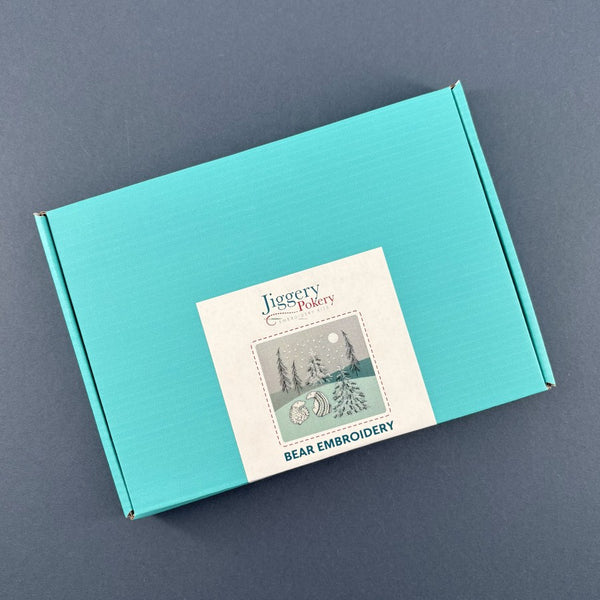 Turquoise mailing box containing the bear embroidery kit with a Jiggery Pokery label.