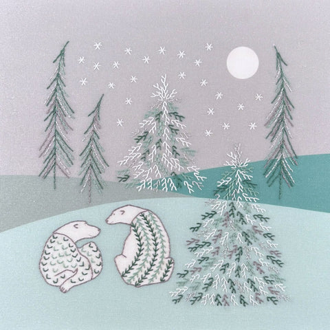 Two polar bears in a winter landscape of soft green and grey with snowy trees and stars under a moonlit sky.