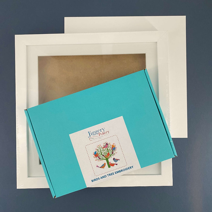 Embroidery gift set includes the birds and tree embroidery kit, a square white frame and a piece of mountboard cut to size.