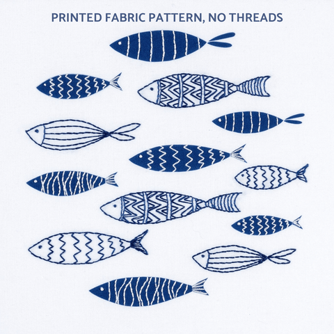 This embroidery pattern creates a shoal of navy blue and white fish on a white background