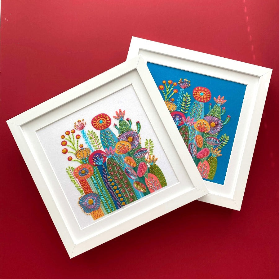 Pair of framed cactus embroideries on blue fabric and white fabric