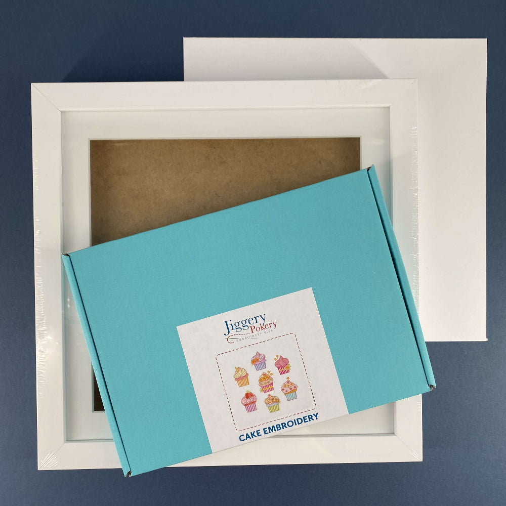 Cakes embroidery kit and square white frame with a piece of mountboard cut to size