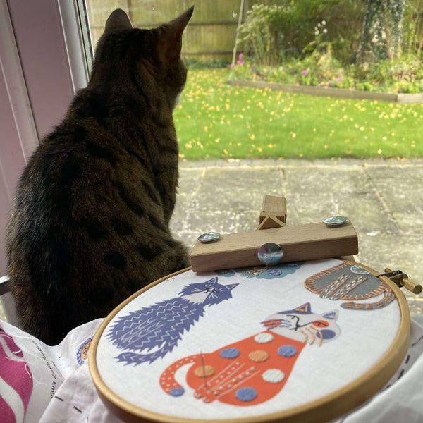 Cat embroidery in hoop with my own cat looking out of the window