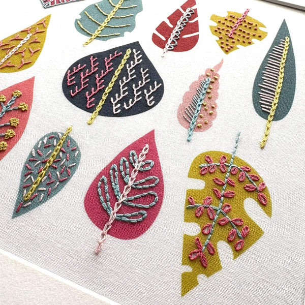 Close-up of embroidery stitches done over pre-printed leaf shapes on fabric pattern