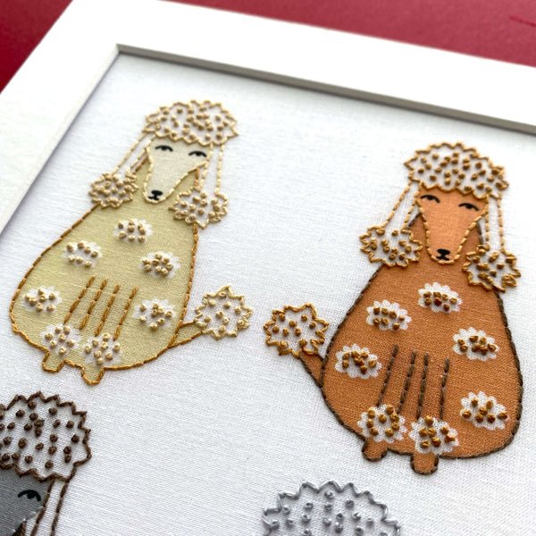 Close-up of two cream and brown poodles from the poodle embroidery pattern.