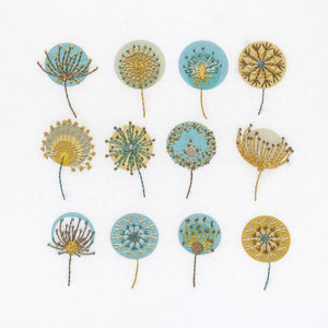 Dandelions embroidery kit shows 12 seed heads stitched in mustard gold, brown, blue and cream DMC thread colours