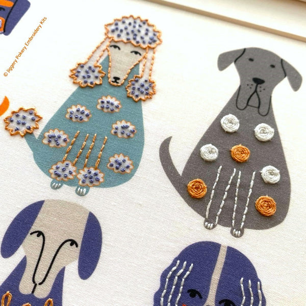 Close up of a grey dog embroidered with woven wheels  and a blue dog with French knots