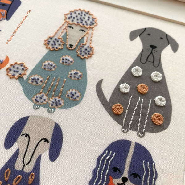 Close up of a grey dog embroidered with woven wheels  and a blue dog with French knots