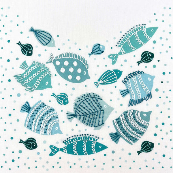 Fish embroidery kit creates a shoal of teal, green and blue fish decorated with simple embroidery stitches. The embroidery is done on top of a background of printed bubbles.