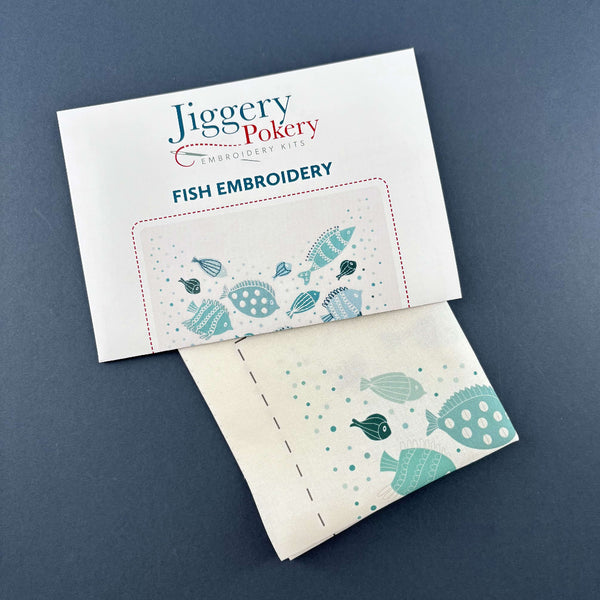 Instructions for Jiggery Pokery's fish embroidery pattern with the printed fabric pattern, shown on a dark blue background.