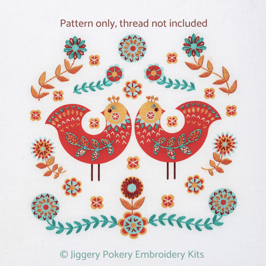 Folk art embroidery pattern showing two birds surrounded by stitched decorations in red, apricot, teal and cream