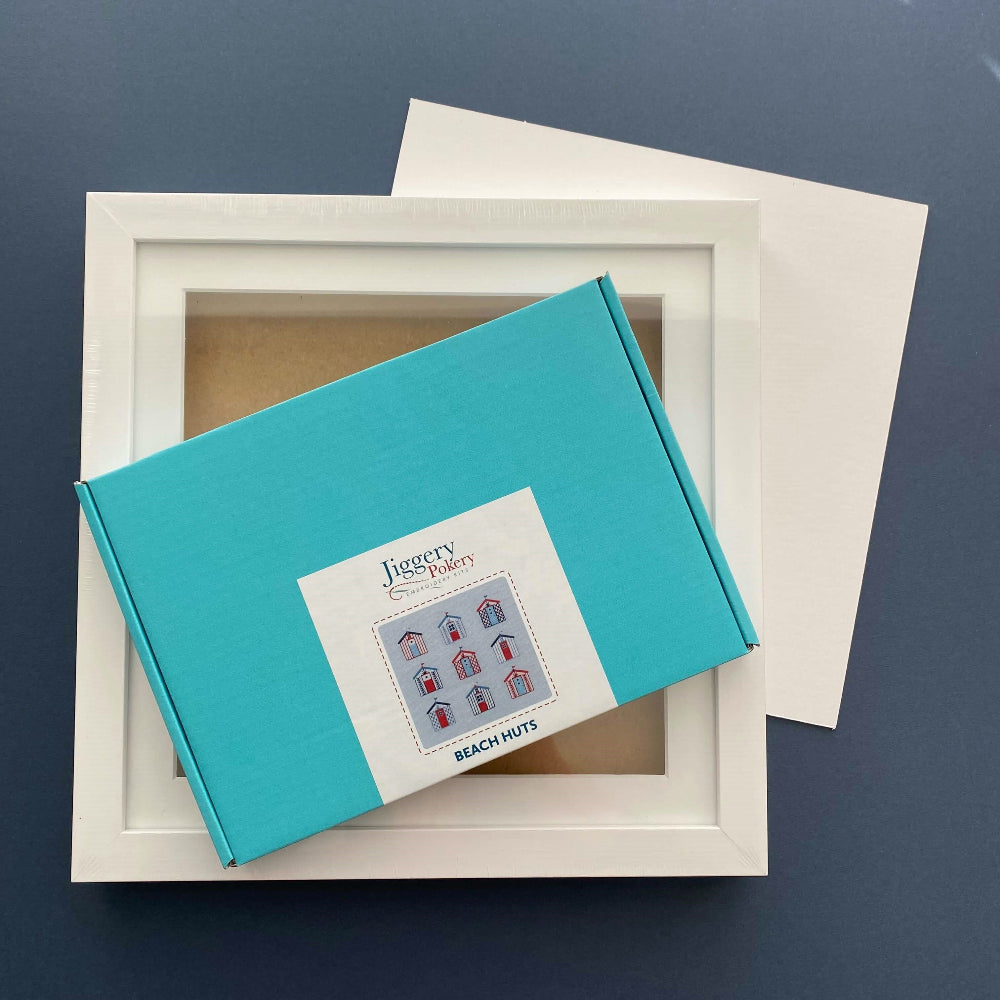 Beach huts embroidery kit and a square white frame with a piece of mountboard cut to size