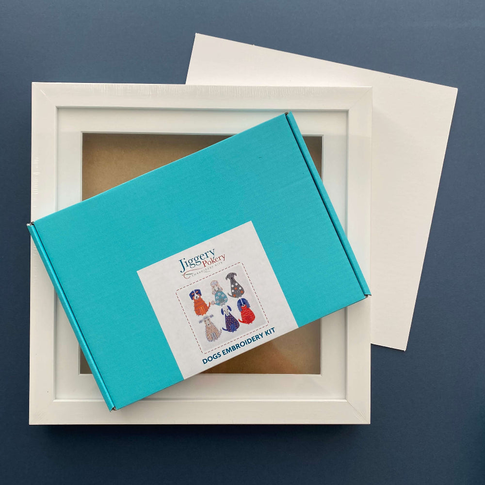 Dogs embroidery kit and a square white frame with a piece of mountboard cut to size