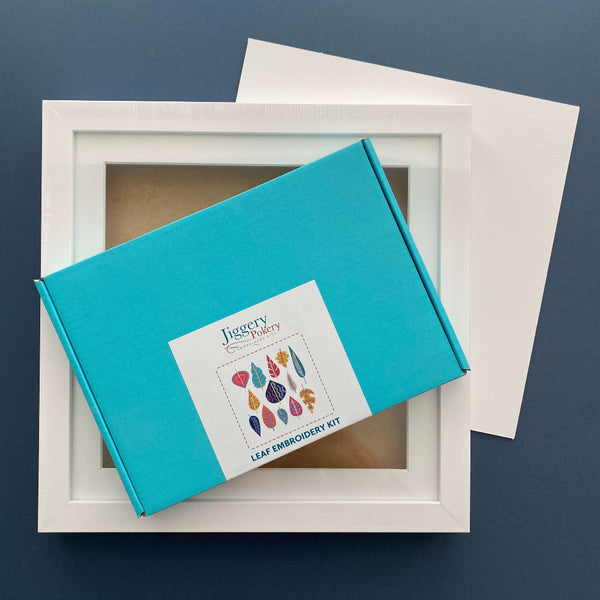 Modern leaves embroidery kit and a square white frame with a piece of mountboard cut to size