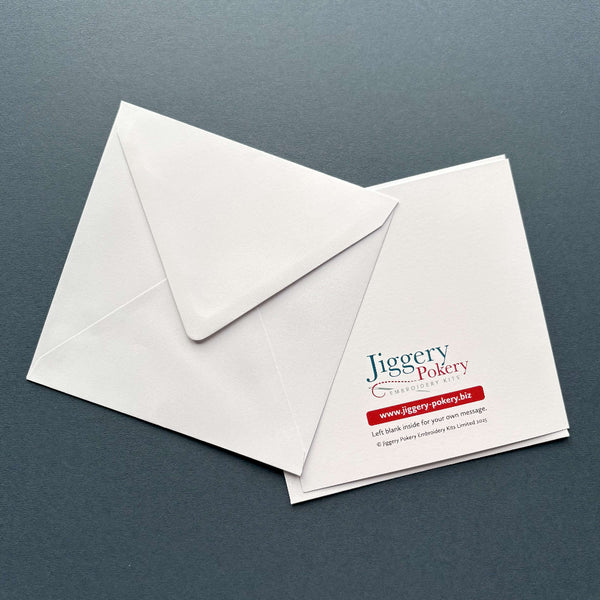 The back of a printed greetings card featuring an embroidery design by Jiggery Pokery. The picture also shows the envelope supplied with the card.