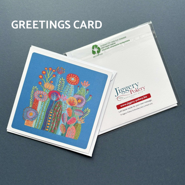 A printed greetings card featuring the cactus embroidery design on a blue background by Jiggery Pokery. Also shows the back of the card and envelope.
