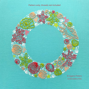 The embroidery pattern creates a wreath of seashells, seaweed and stars with easy embroidery stitches in green, pink and coral