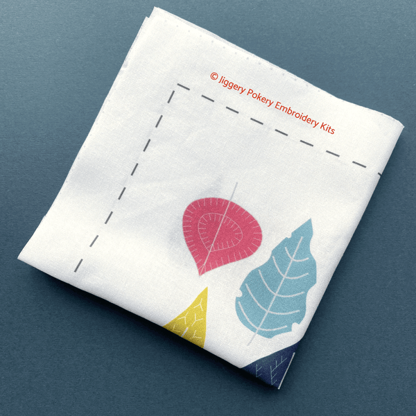 Pattern for modern leaves embroidery design printed on fabric, shown on dark blue background