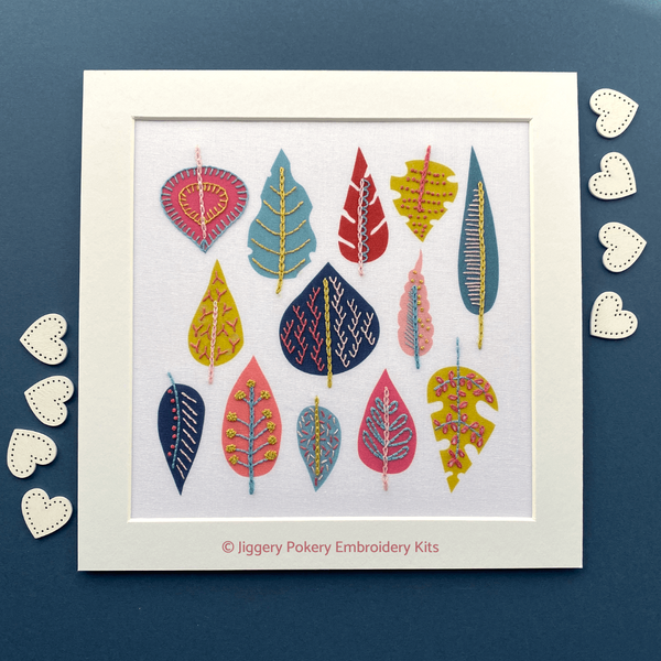 Leaf embroidery design in mount with hearts on navy blue background