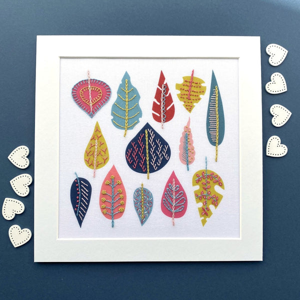 Leaf embroidery design in mount with hearts on navy blue background