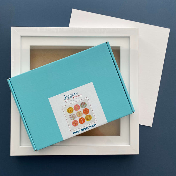 Pink and orange trees embroidery kit and square white frame with a piece of mountboard cut to size