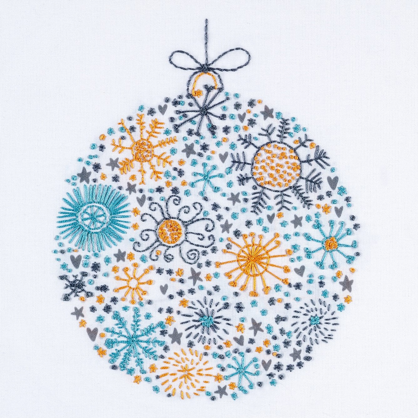 The Scandinavian Christmas embroidery design shows a festive bauble stitched in dark grey, teal and orange gold DMC thread colours colours