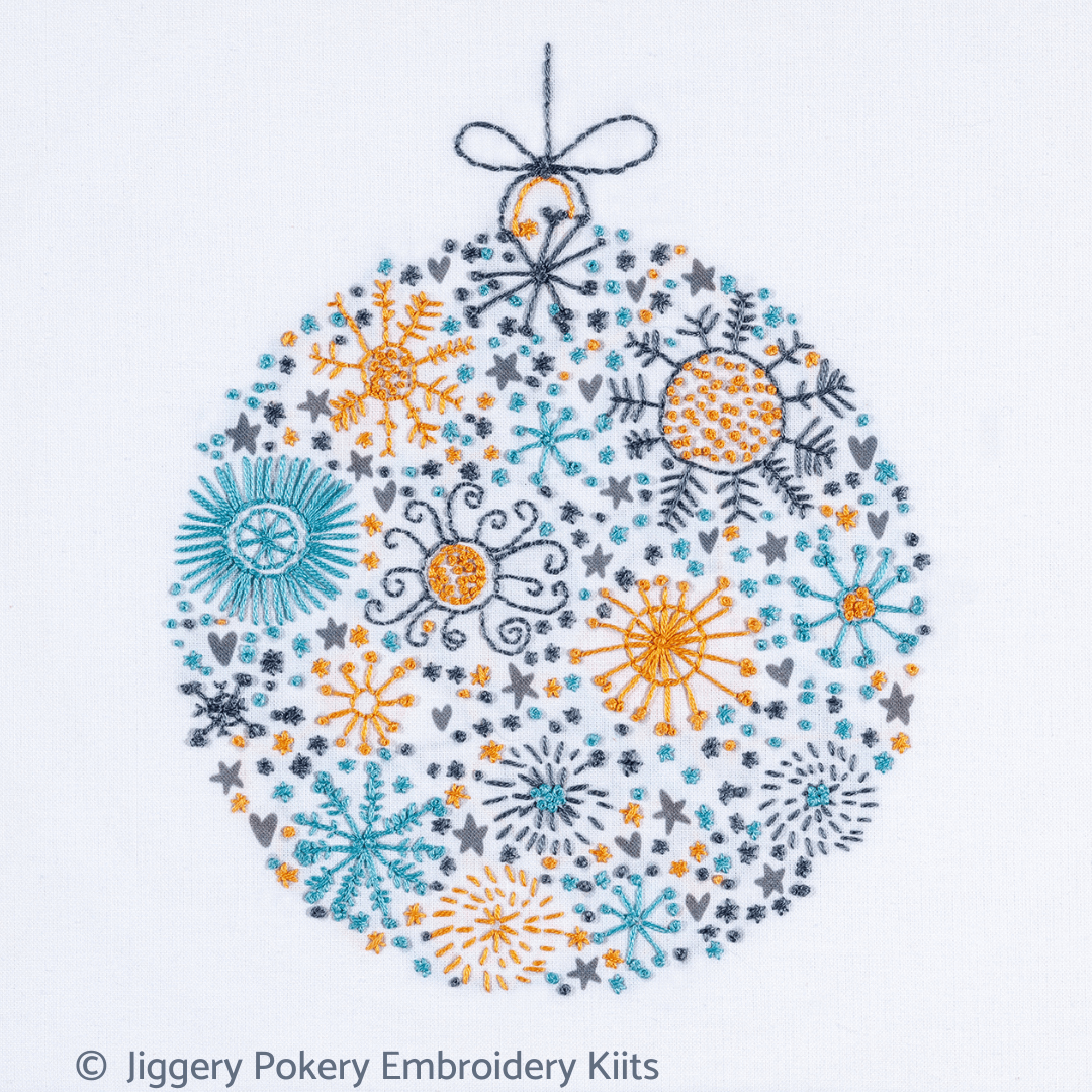 Simple Christmas embroidery kit showing a festive ball in dark grey, teal and orange gold colours