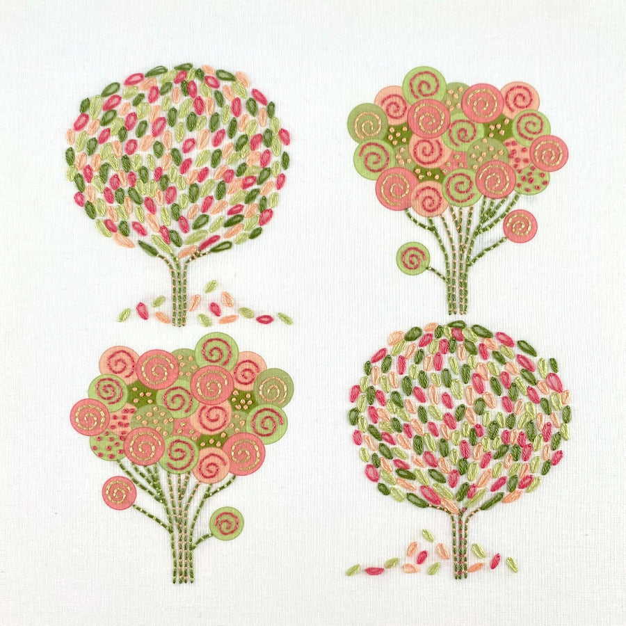 Spring embroidery kit showing four trees stitched in pink, peach and green DMC threads