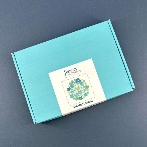 Teal box with a Jiggery Pokery label featuring the spring flowers embroidery design.