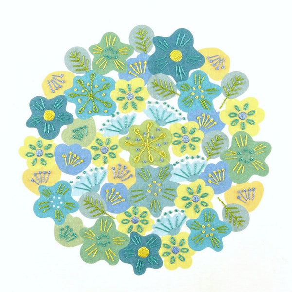Spring flowers embroidery kit creates a circle of brightly coloured blue, green and yellow flowers