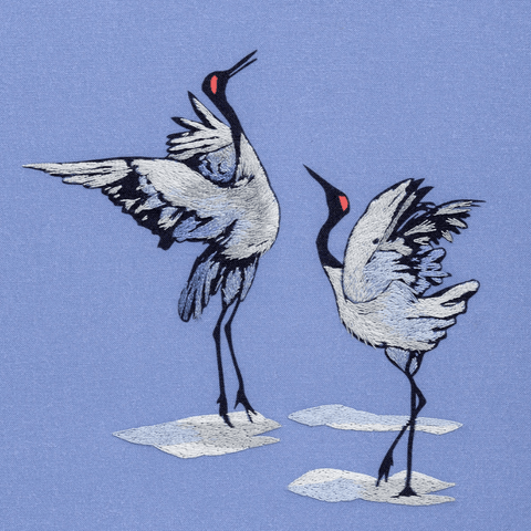 Easy thread painting embroidery design creates two Japanese style dancing crane birds. Shown on a mauve background with the stitching done in pale grey, grey, pale mauve and lilac.