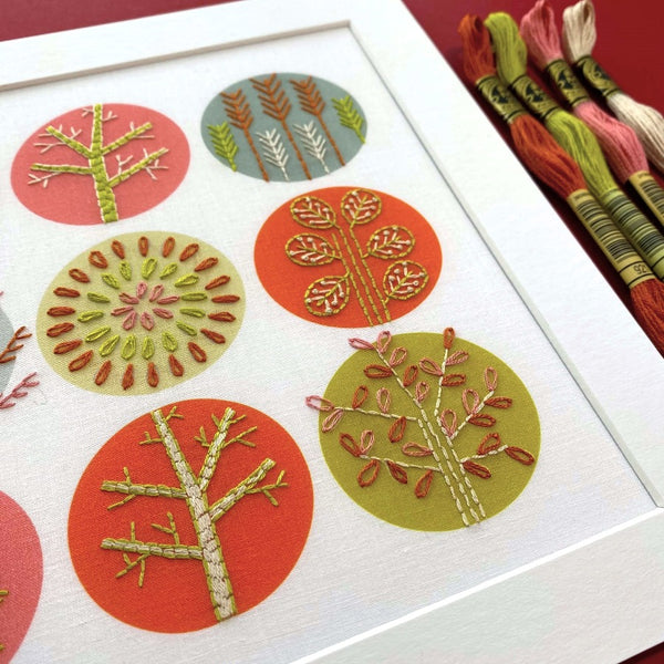 Pink and orange trees embroidery showing trees stitched onto pre-printed circles