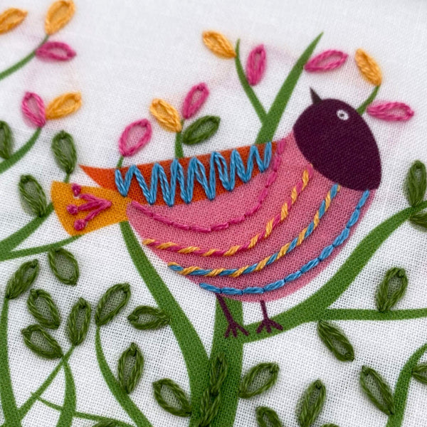 One bird from the birds in a tree embroidery pattern showing whipped back stitch on its pink breast markings