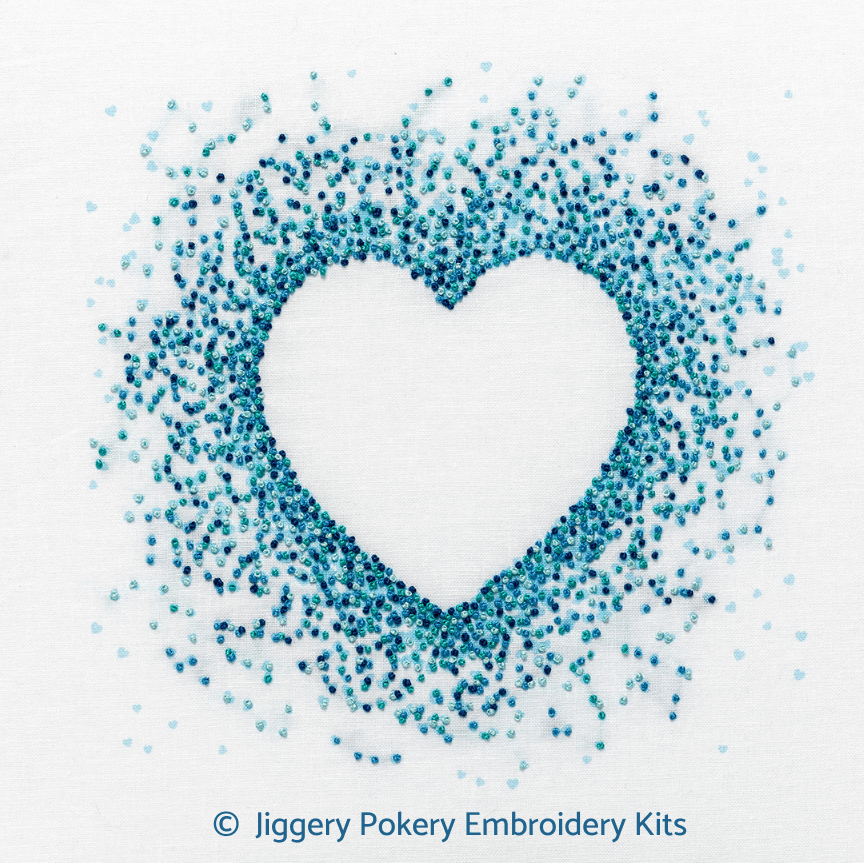 Blue hearts embroidery kit by Jiggery Pokery showing a negative space heart outline created by stitches in aquamarine, turquoise, pale and dark blue