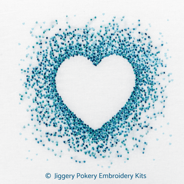 Blue hearts embroidery kit by Jiggery Pokery showing a negative space heart outline created by stitches in aquamarine, turquoise, pale and dark blue