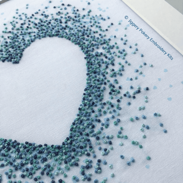 Blue hearts embroidery kit close-up showing French knots in pale blue, turquoise, mid blue and dark blue