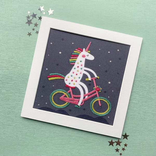 Unicorn embroidery mounted, shown on a green background with stars