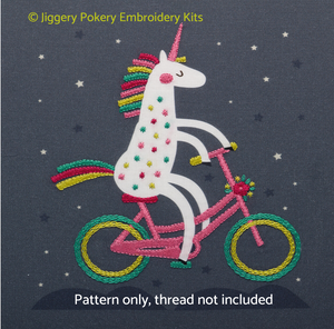 Unicorn hand embroidery pattern showing a white unicorn with pink, red, green and lime mane and tail riding a bike
