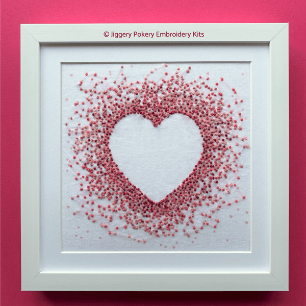Pink hearts embroidery design in white square frame on pink background