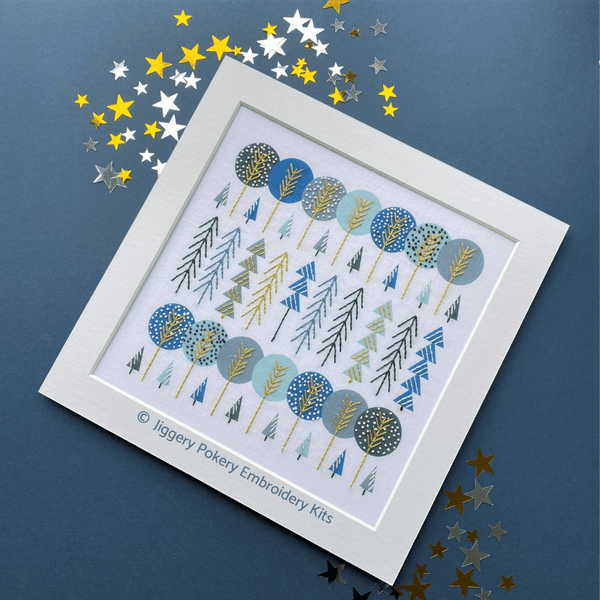 Simple trees embroidery mounted, shown on dark blue background with gold and silver stars