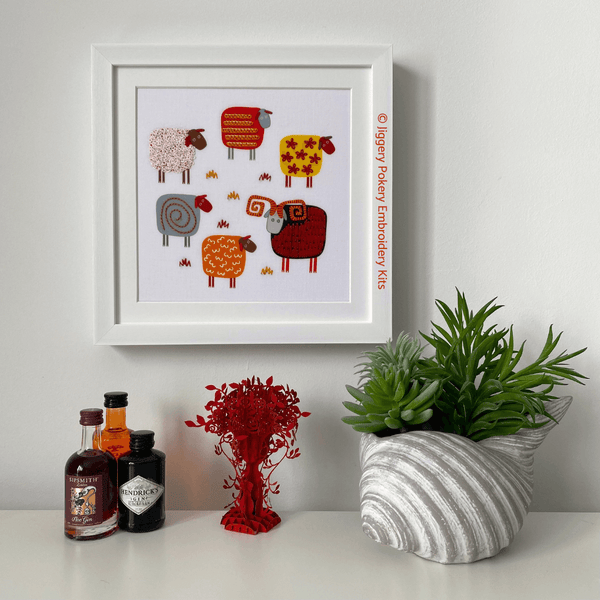 Sheep embroidery kit in display frame hanging on wall