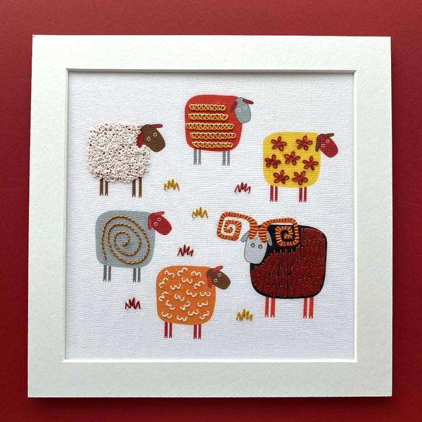 Sheep embroidery design mounted on red background