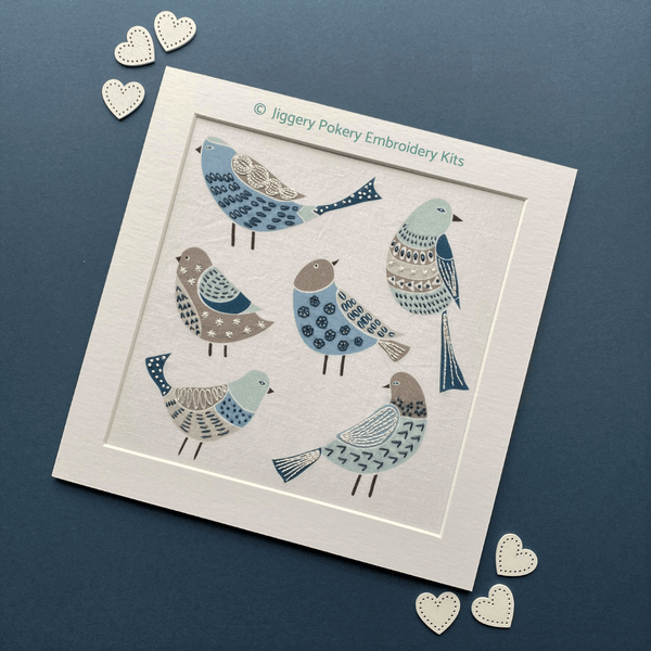 Simple birds embroidery pattern mounted on blue background shown with hearts